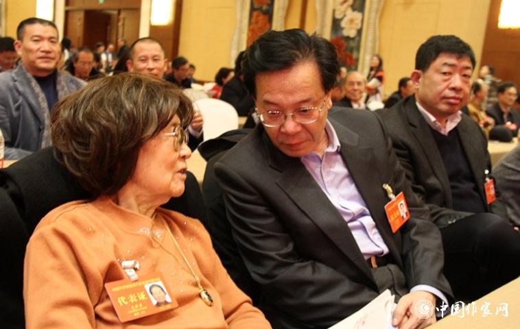 文潔若、李福明等代表在報告會前交談。