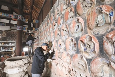 　2023年3月31日，大足石刻小佛灣修復(fù)現(xiàn)場，修復(fù)人員正在對石窟造像進(jìn)行清理。小佛灣石窟保護(hù)修復(fù)工程于2019年6月啟動，目前已完成整個工程量的六成。  　　黃 舒攝（人民圖片）