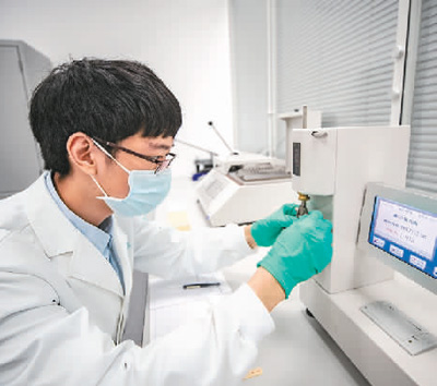  在重慶三峽文物科技保護基地內(nèi)，“文物醫(yī)生”運用各種“診療”設(shè)備對手里的文物進行精準(zhǔn)治療，讓其煥發(fā)出新的活力。   圖為2022年，“文物醫(yī)生”利用耐折度儀對紙張的耐折度進行測試。   新華社記者 黃 偉攝