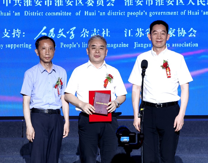 中國作家協(xié)會黨組成員、書記處書記、《人民文學》雜志社主編施戰(zhàn)軍，淮安市人大常委會副主任范更生為王躍文頒獎