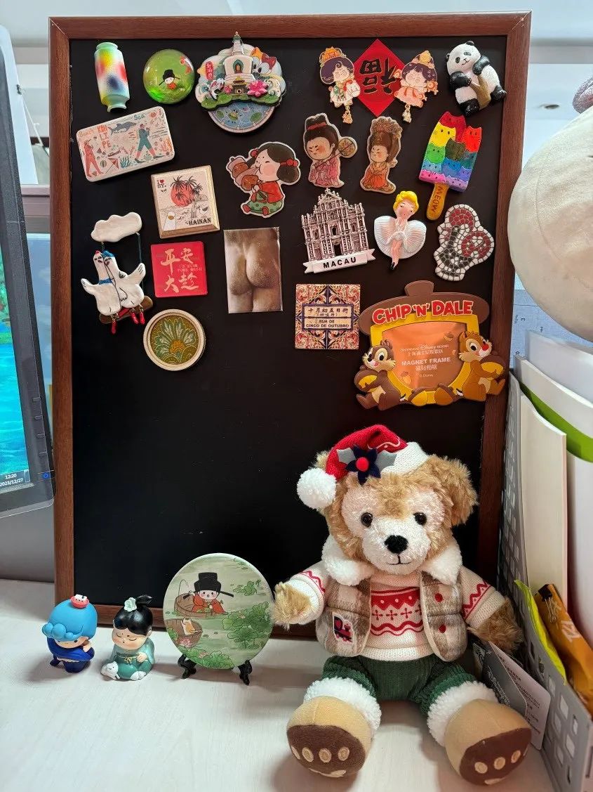 辦公桌一角的冰箱貼小黑板，是朋友和自己從各地帶回來的愛與新知