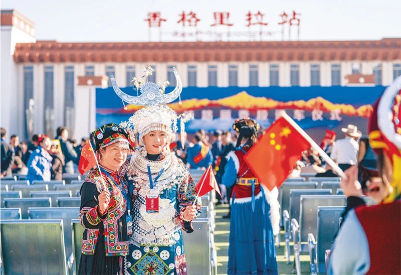 2023年11月26日，麗江至香格里拉鐵路開通運營。麗香鐵路起自云南省麗江市玉龍納西族自治縣麗江站，接入云南省迪慶藏族自治州香格里拉市香格里拉站，穿越青藏高原橫斷山區(qū)腹地，途經(jīng)多個民族聚集地。圖為麗香鐵路開通當日，參加通車儀式的少數(shù)民族代表拍照留念。 新華社記者 陳欣波/攝