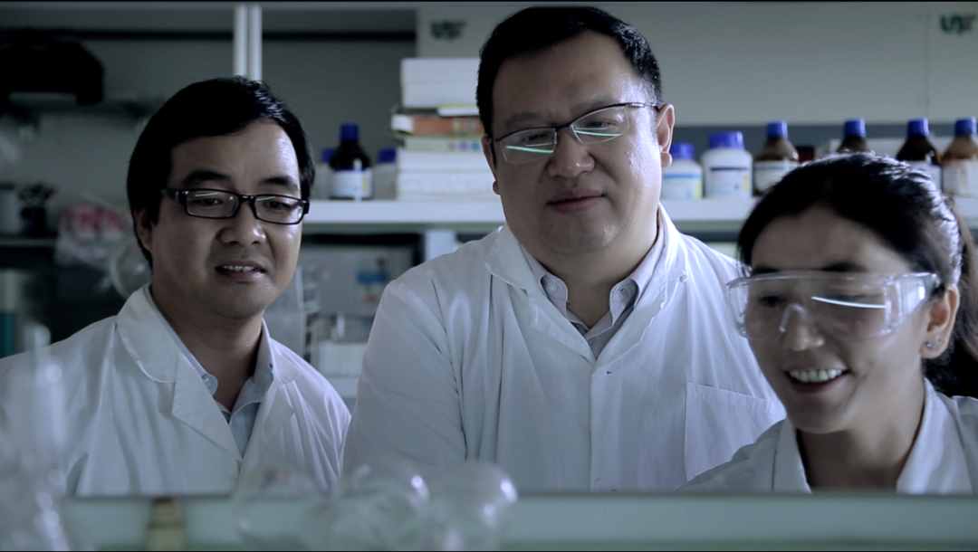 鐘揚（中間）和學(xué)生在實驗室