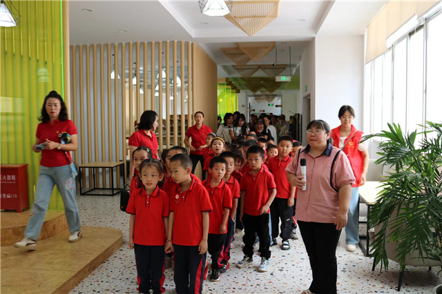 李躍慧拿著話(huà)筒在給進(jìn)圖書(shū)館參觀的小朋友做講解