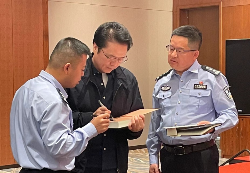 活動期間，陳彥（圖中）在給警營作家簽名。