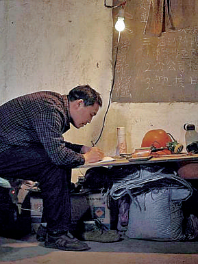 礦工陳年喜在燈下寫作。資料圖片