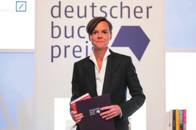     作家安特耶·拉維克·施特魯貝爾在2021年德國圖書獎頒獎典禮上手持《藍色女人》和獲獎證書。攝影：托馬斯·洛內(nèi)斯