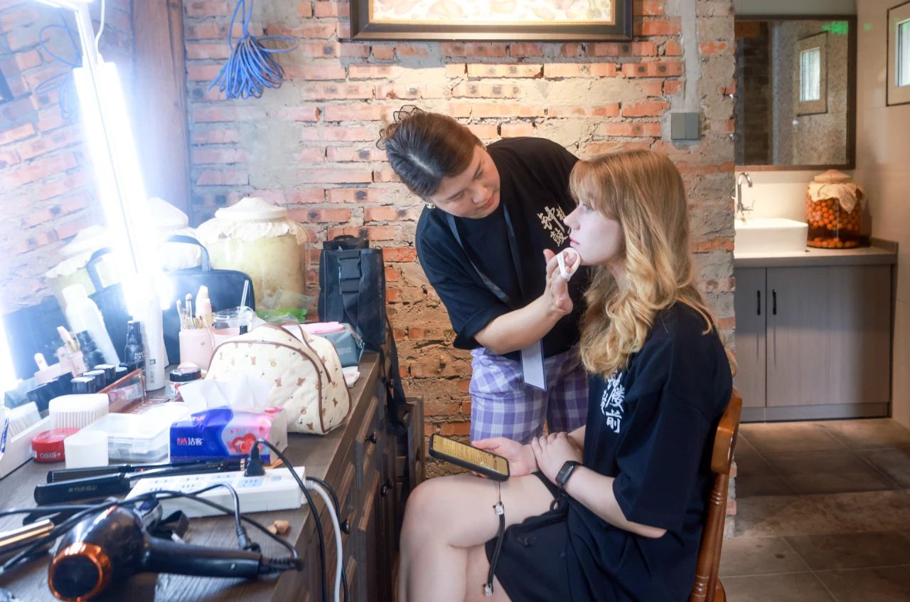 2025年6月30日，百集微短劇《鐘鼓樓前》在北京鼓樓前開機。圖為俄羅斯籍女演員瑪利亞在開拍前化妝。 中新社記者 賈天勇 攝