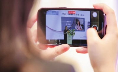 在2024上海國際文學(xué)周主論壇的會場，一位觀眾在用手機(jī)錄制日本推理小說家湊佳苗的發(fā)言。上海國際文學(xué)周供圖